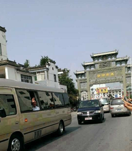 胡锦涛一到绩溪就打开车窗向乡亲们招手致意。