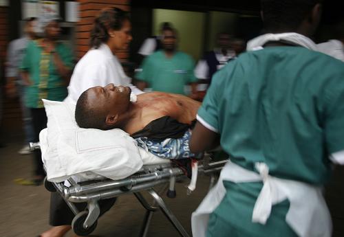An injured man is wheeled in upon his arrival at the Aga Khan hospital in Nairobi, on September 21,2013 after masked attackers stormed a packed upmarket shopping mall, spraying gunfire and killing 39 people and wounding dozens more before holing themselves up in the complex. [Xinhua/AFP Hoss Njuguna] 
