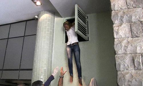 An image grab taken from AFP TV shows a Kenyan woman coming out of an air vent where she was hiding during an attack by masked gunmen at a shopping mall in Nairobi on September 21, 2013. [Xinhua/AFP]
