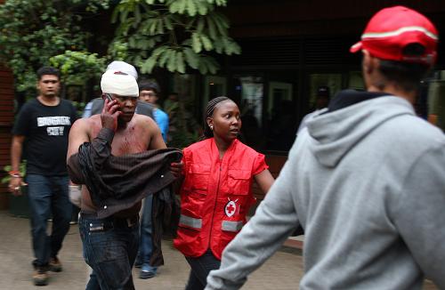 An injured Kenyan man talks on the phone upon his arrival at the Aga Khan Hospital in Nairobi, on September 21,2013 after masked attackers stormed a packed upmarket shopping mall, spraying gunfire and killing 39 people and wounding dozens more before holing themselves up in the complex. [Xinhua/AFP]