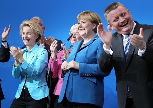 German Chancellor and leader of the Christian Democratic Union(CDU) Angela Merkel (2nd, Right）and her partners celebrate afer first exit polls in the German general election at the CDU party headquarters in Berlin September 22, 2013. [Xinhua]