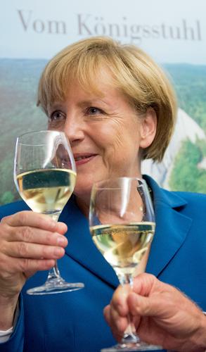 German Chancellor Angela Merkel drinks a glass of vine during the election party of her Christian Democratic Union (CDU) party at the party's headquarters in Berlin on September 22, 2013. German Chancellor Angela Merkel won a third term in elections but her conservatives may be forced to govern in a 'grand coalition' with the centre-left Social Democrats, exit polls showed.