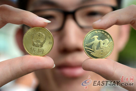 9月23日，市民小章向记者展示纪念币。当日，中国人民银行发行“和”字书法——行书普通纪念币。该币面额为5元，发行数量为5000万枚。