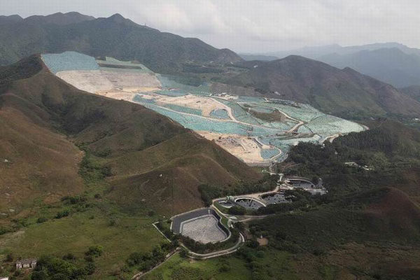 Covered largely by green plastic material, one woman in Shenzhen said she initially thought the Tuen Mun landfill was a scenic spot, until she moved into her new home at Shenzhen Bay and was inundated by the smell of waste. Many people, including the woman, have criticized the Hong Kong authorities' expansion plans. [Photo by Edmond Tang / China Daily]