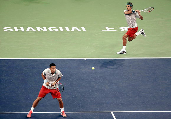 Roger Federer (top), with his partneRoger Federer (top), with his partner Zhang Ze, hits a shot to Kevin Anderson and Dmitry Tursunov in a doubles match at the Shanghai Masters yesterday in Minhang District. Federer and Zhang won in straight sets.