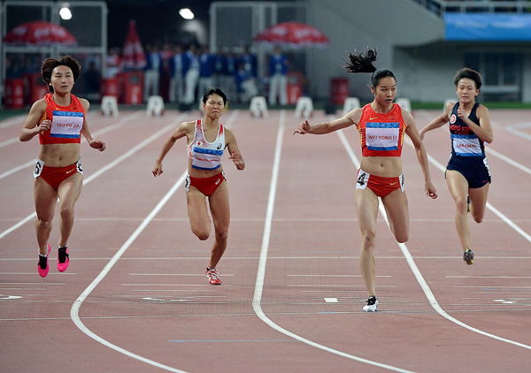 Wei Yongli (second right) crosses the finish line to win the women’s 100 meters final ahead of runner-up Tao Yujia (left) with third-placed Akane Kimura of Japan (second left) and Fong Yee Pui of China’s Hong Kong at the East Asian Games yesterday. 