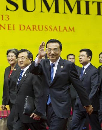 Chinese Premier Li Keqiang (front) waves to journalists before taking a group photo with other leaders who attend the 8th East Asia Summit (EAS) in Bandar Seri Begawan, Brunei, Oct. 10, 2013. [Huang Jingwen/Xinhua]