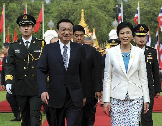 Visiting Chinese Premier Li Keqiang (L, front) and his Thai counterpart Yingluck Shinawatra review an honor guard during a welcoming ceremony before their meeting in Bangkok, Thailand, Oct. 11, 2013. Li Keqiang met with Yingluck Shinawatra in Bangkok on Friday. [Rao Aimin/Xinhua]