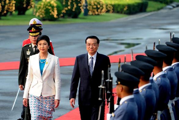 Visiting Chinese Premier Li Keqiang (R) and his Thai counterpart Yingluck Shinawatra review an honor guard during a welcoming ceremony before their meeting in Bangkok, Thailand, Oct. 11, 2013. Li Keqiang met with Yingluck Shinawatra in Bangkok on Friday. [Liu Jiansheng/Xinhua]