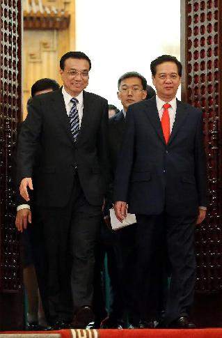 Visiting Chinese Premier Li Keqiang (L) walks out of the conference hall with his Vietnamese counterpart Nguyen Tan Dung after their talks in Hanoi, Vietnam, Oct. 13, 2013. Li held talks with Nguyen Tan Dung in Hanoi on Sunday. [Liu Weibing/Xinhua]