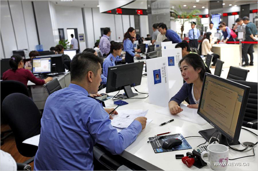 People ask for advice and information about enterprise registration application at the service lobby of Shanghai Free Trade Zone (FTZ) in Shanghai, east China, Oct. 14, 2013. The newly-launched Shanghai pilot free trade zone (FTZ) started offering enterprise registration service recently. 