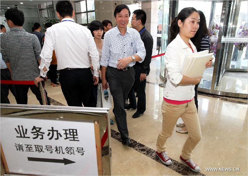 People come to the service lobby of Shanghai Free Trade Zone (FTZ) to consult about enterprise registration application, in Shanghai, east China, Oct. 14, 2013. The newly-launched Shanghai pilot free trade zone (FTZ) started offering enterprise registration service recently. 