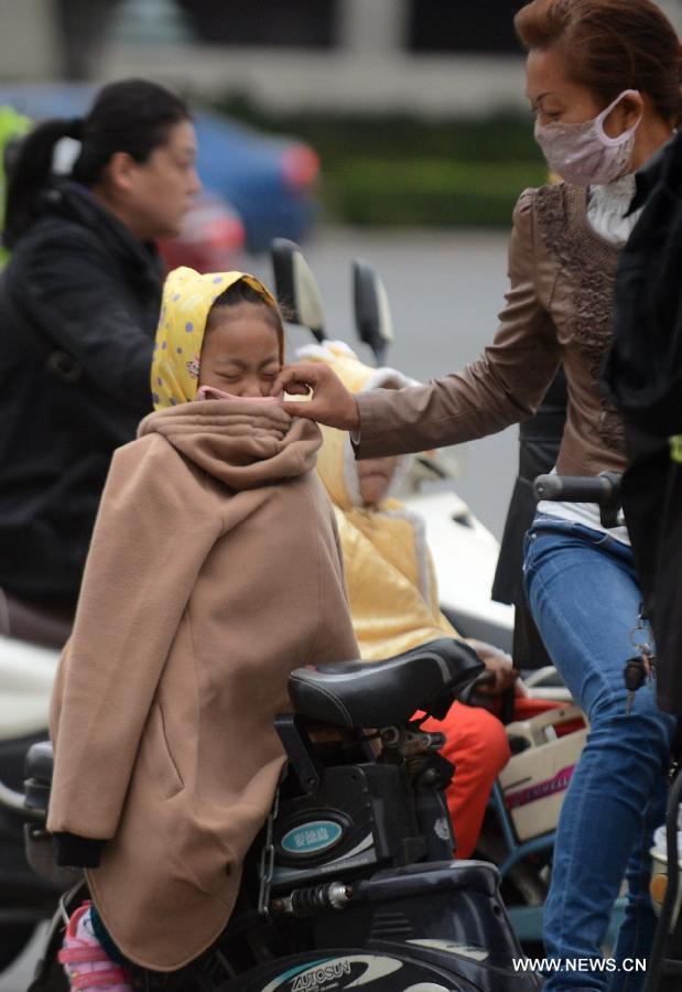 A young girl is helped to keep warm as a cold wave hit Yangzhou City, east China&apos;s Jiangsu Proince, Oct. 15, 2013.