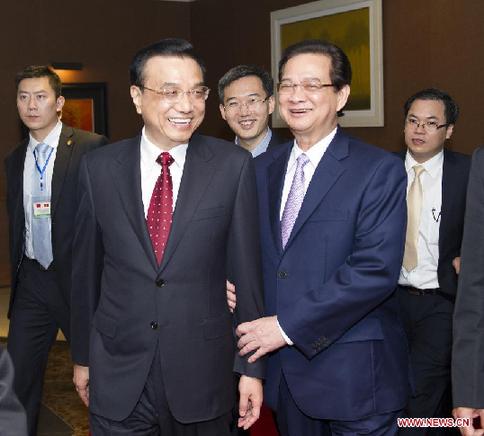Chinese Premier Li Keqiang (L, front) and his Vietnamese counterpart Nguyen Tan Dung (R, front) enter the hall prior to a luncheon attended by representatives of the two countries' business communities, in Hanoi, Vietnam, Oct. 15, 2013. [Huang Jingwen/Xinhua]