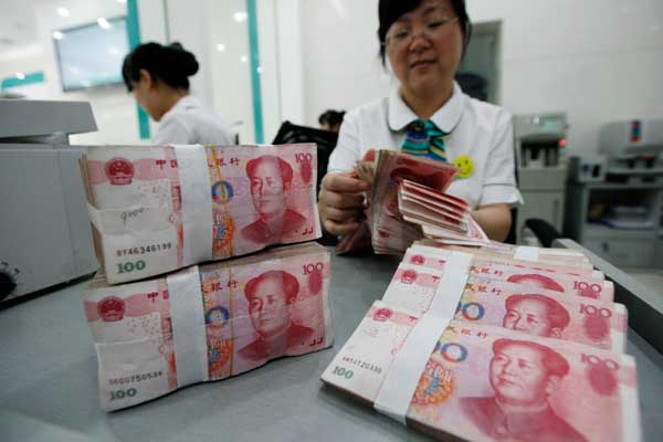 A teller counts bank notes at one of Industrial and Commercial Bank of China Ltd's branches in Huaibei, Anhui province. [provided to china daily]