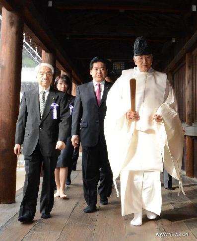 Japanese lawmakers are led by a Shinto priest as they visit the war-linked controversial Yasukuni Shrine for worship, in Tokyo, on Oct. 18, 2013. 