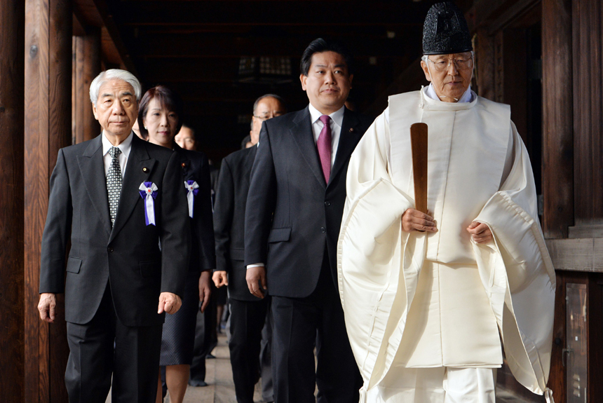 Japanese lawmakers are led by a Shinto priest as they visit the war-linked controversial Yasukuni Shrine for worship, in Tokyo, on Oct. 18, 2013. [Photo/Xinhua]