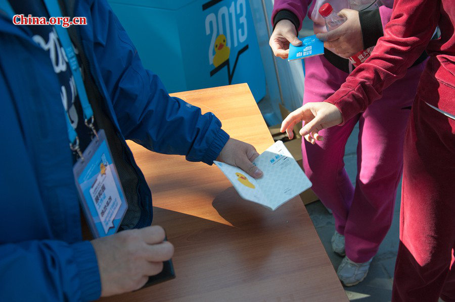 Tourists line up to receive Rubber Duck stamps on their Duck passports at the Summer Palace in Beijing on Sunday. [Photo / Chen Boyuan / China.org.cn]