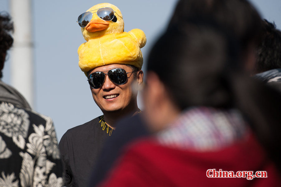 A guest who attends the Farewell, Rubber Duck ceremony wears duck-style accessories, attracting visitors attention. [Photo / Chen Boyuan / China.org.cn]