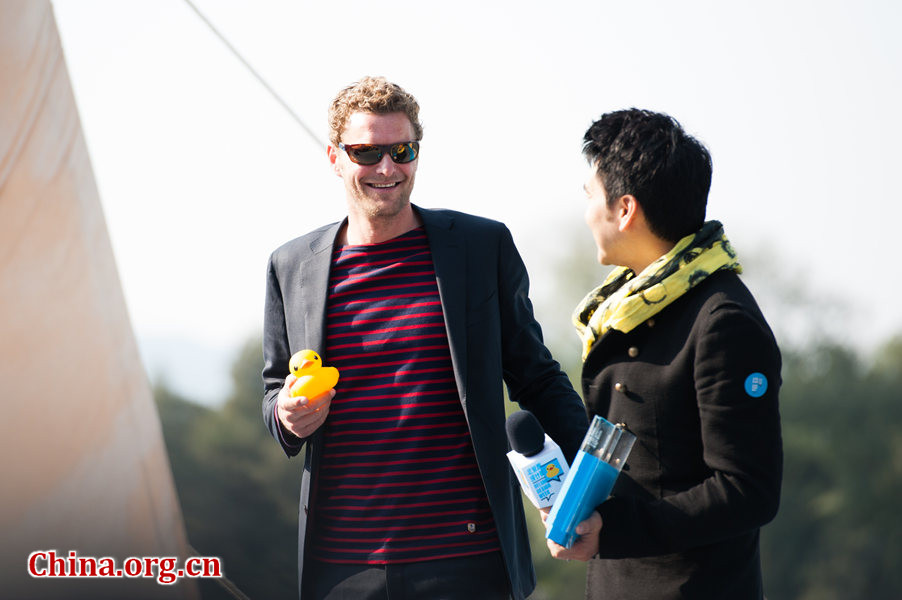 Celebrated pop singer Lin Yilun (R), Chairman of the newly found China Rubber Duck Fan Club, makes his appearance together with Dutch artist Florentijn Hofman, dubbed the 'father of the rubber duck,' at the Summer Palace on Thursday in bidding a fond farewell to the Dutch Rubber Duck. [Photo / Chen Boyuan / China.org.cn ]