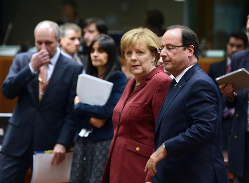 French President Francois Hollande (R) and German Chancellor Angela Merkel arrive at the European Council meeting at the EU headquarters on October 24, 2013 in Brussels. European Union leaders Friday opened a summit dominated by a row over American spying that targeted German Chancellor Angela Merkel. [Xinhua Photo]