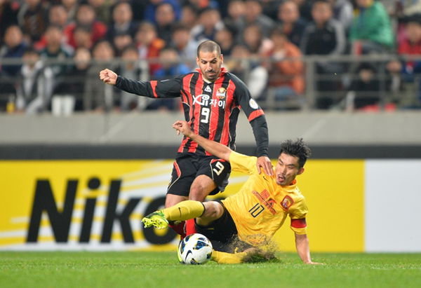 Guangzhou Evergrande's Zheng Zhi tackled Sergio Escudero in the first leg of AFC Champions League final.