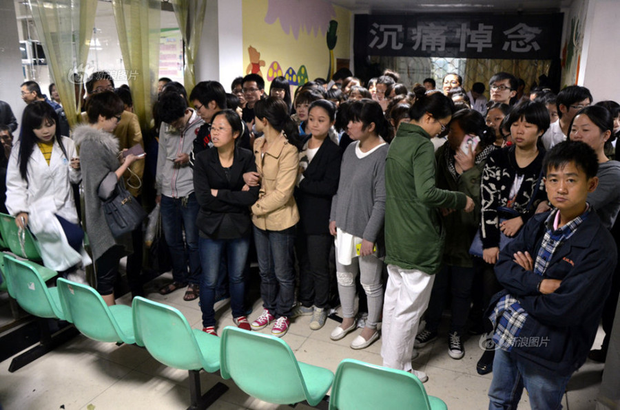 Doctors and nurses at No. 1 Hospital in Wenling, Zhejiang Province, gather at the temporary autopsy room on Sunday, guarding the body of Dr. Wang Yunjie, who was stabbed to death two days earlier while at work. Only a few staff members held their posts. [Photo / Sina]