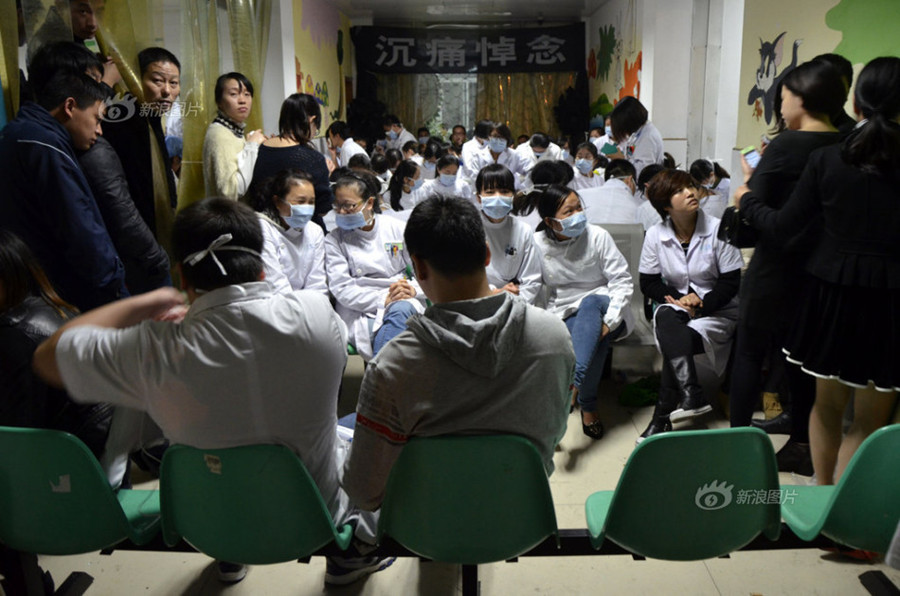 Doctors and nurses at No. 1 Hospital in Wenling, Zhejiang Province, gather at the temporary autopsy room on Sunday, guarding the body of Dr. Wang Yunjie, who was stabbed to death two days earlier while at work. Only a few staff members held their posts. [Photo / Sina]