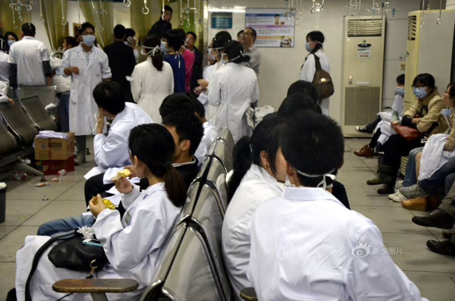 Doctors and nurses at No. 1 Hospital in Wenling, Zhejiang Province, gather at the temporary autopsy room on Sunday, guarding the body of Dr. Wang Yunjie, who was stabbed to death two days earlier while at work. Only a few staff members held their posts. [Photo / Sina]