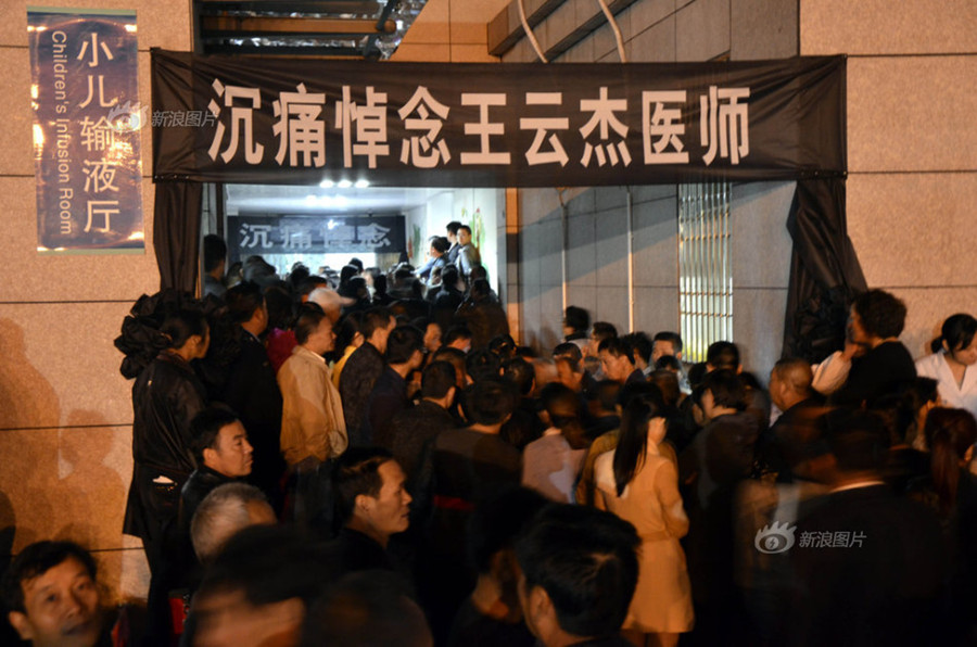 Doctors and nurses at No. 1 Hospital in Wenling, Zhejiang Province, gather at the temporary autopsy room on Sunday, guarding the body of Dr. Wang Yunjie, who was stabbed to death two days earlier while at work. Only a few staff members held their posts. [Photo / Sina]