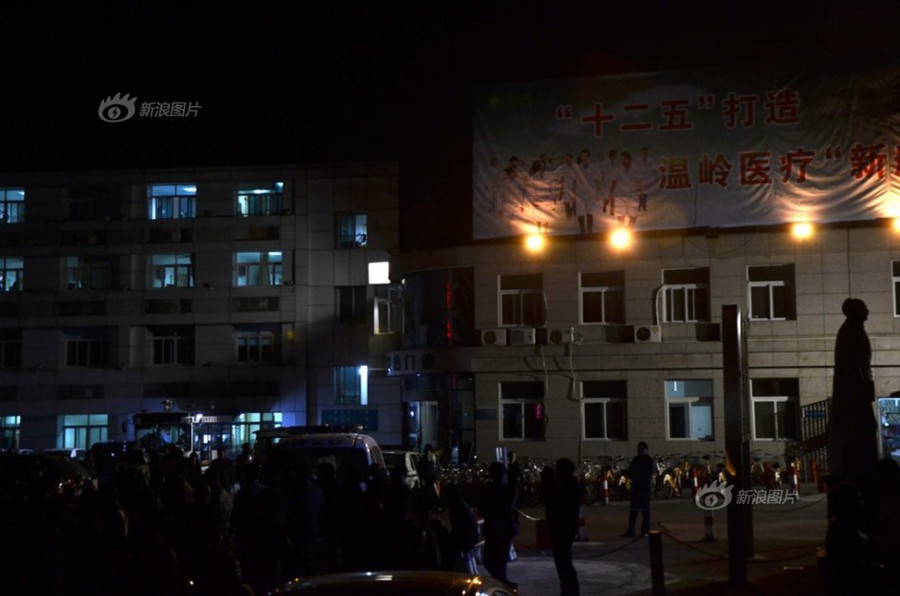 Doctors and nurses at No. 1 Hospital in Wenling, Zhejiang Province, gather at the temporary autopsy room on Sunday, guarding the body of Dr. Wang Yunjie, who was stabbed to death two days earlier while at work. Only a few staff members held their posts. [Photo / Sina]