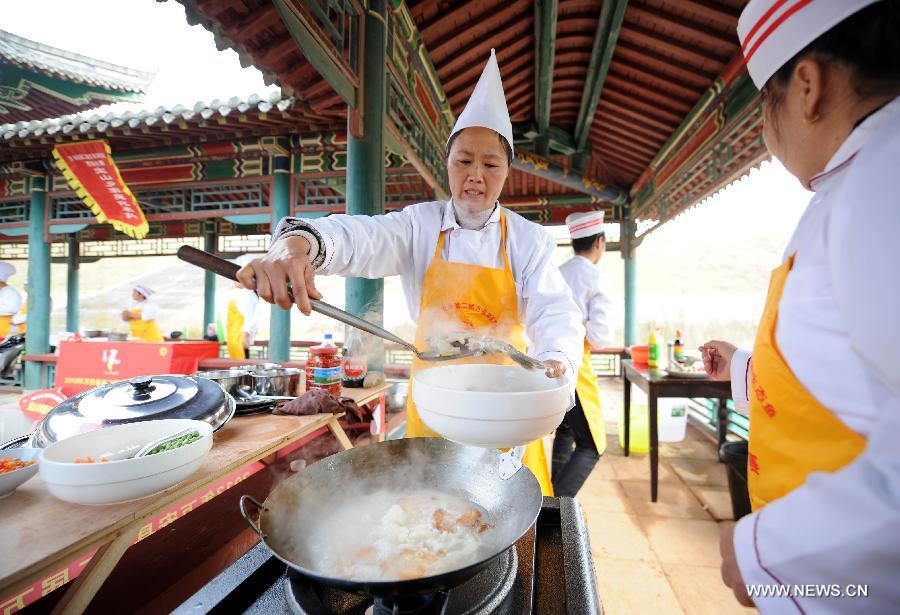 A contestant cooks at a fish cooking contest held in Wan'an County, east China's Jiangxi Province, Oct. 30, 2013. 