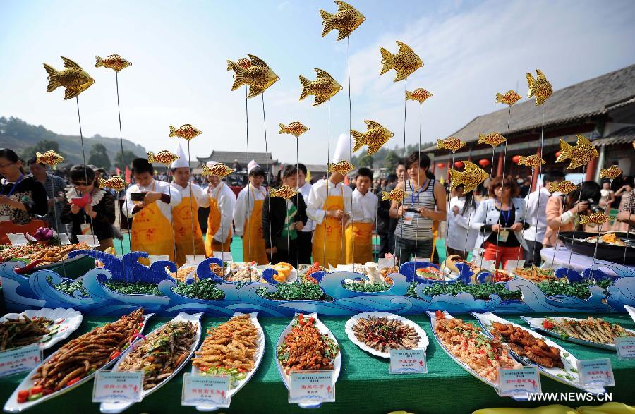 Contestants introduce their dishes at a fish cooking contest held in Wan'an County, east China's Jiangxi Province, Oct. 30, 2013.