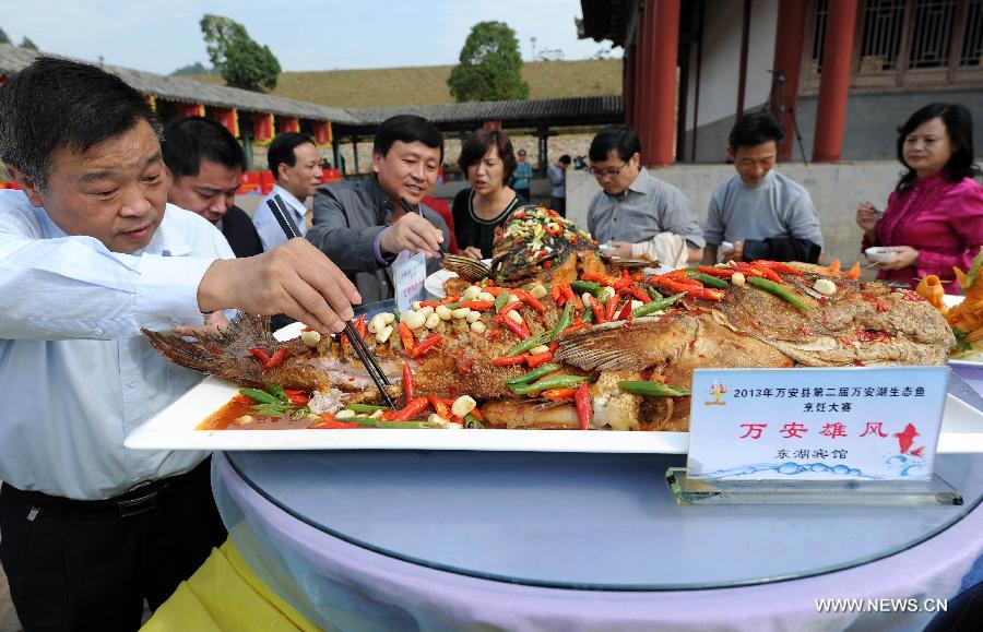 People taste various fish dishes at a fish cooking contest held in Wan'an County, east China's Jiangxi Province, Oct. 30, 2013. 