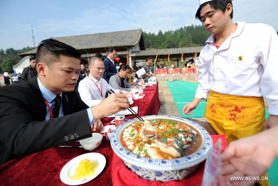 Judges grade works of contestants at a fish cooking contest held in Wan'an County, east China's Jiangxi Province, Oct. 30, 2013. 