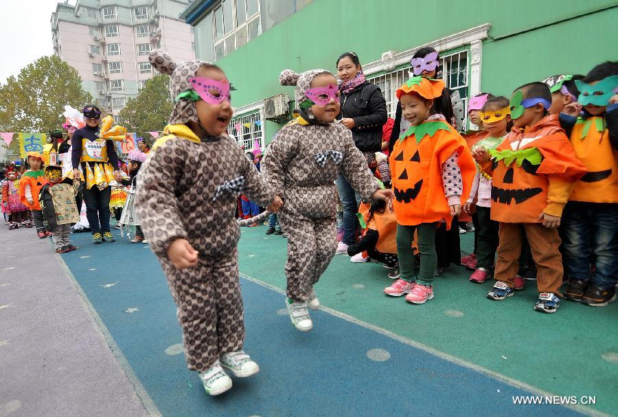 A pair of twins show costumes made with recycled materials to greet the Halloween in a kindergarten in Handan City, north China's Hebei Province, Oct. 31. The World Thrift Day fell on Thursday, a day before the All-Saint's Day this year.