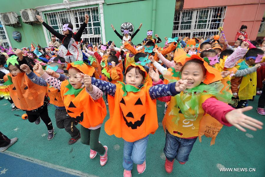 Teachers and children dance in Halloween costumes in a kindergarten in Handan City, north China's Hebei Province, Oct. 31. The World Thrift Day fell on Thursday, a day before the All-Saint's Day this year. 