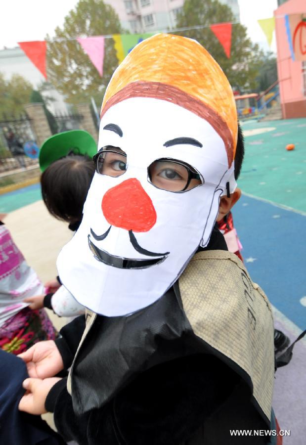 A child shows a Halloween mask he made in a kindergarten in Handan City, north China's Hebei Province, Oct. 31. The World Thrift Day fell on Thursday, a day before the All-Saint's Day this year.