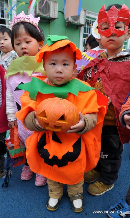 Children show costumes they made to greet the Halloween in a kindergarten in Handan City, north China's Hebei Province, Oct. 31. The World Thrift Day fell on Thursday, a day before the All-Saint's Day this year. 