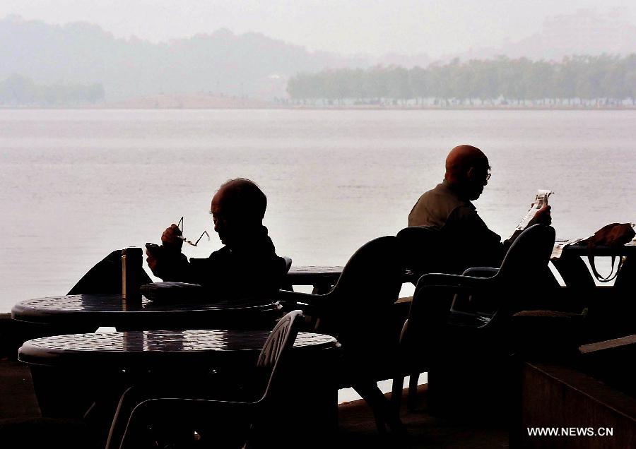 People rest by the West Lake in Hangzhou, capital of east China's Zhejiang Province, Nov. 4, 2013