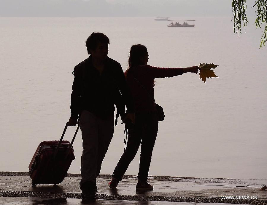 People enjoy the scenery of the West Lake in Hangzhou, capital of east China's Zhejiang Province, Nov. 4, 2013