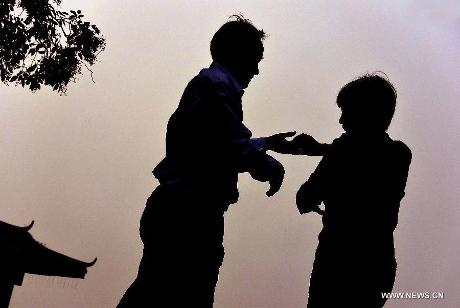 People dance by the West Lake in Hangzhou, capital of east China's Zhejiang Province, Nov. 4, 2013