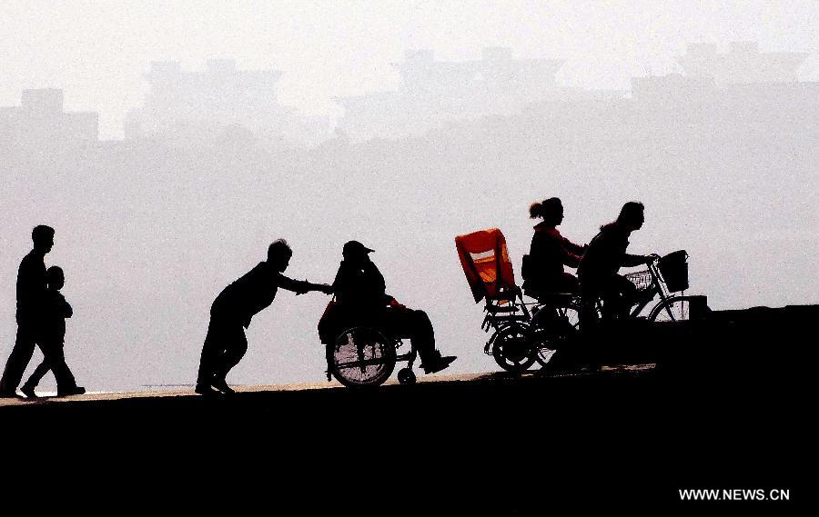 People walk by the West Lake in Hangzhou, capital of east China's Zhejiang Province, Nov. 4, 2013