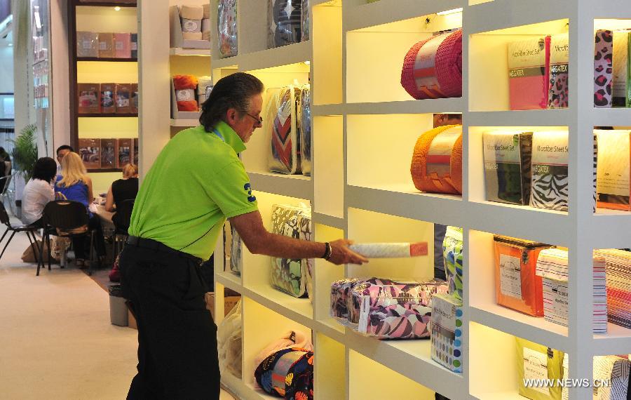 Photo taken on Nov. 4, 2013 shows a foreign purchaser selects products at the 114th China Import and Export Fair, or the Canton Fair, in Guangzhou, capital of south China&apos;s Guangdong Province. The autumn session of the Canton Fair wrapped up on Monday, showed a drop in both transaction volume and fair attendance. 