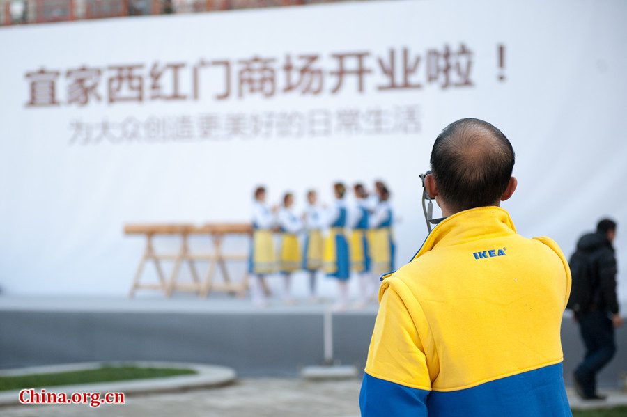 An IKEA staff member films a Swedish style dance on Thursday morning in Beijing before Beijing&apos;s second IKEA store, IKEA Xihongmen store officially opens on Thursday. [Photo / Chen Boyuan / China.org.cn]