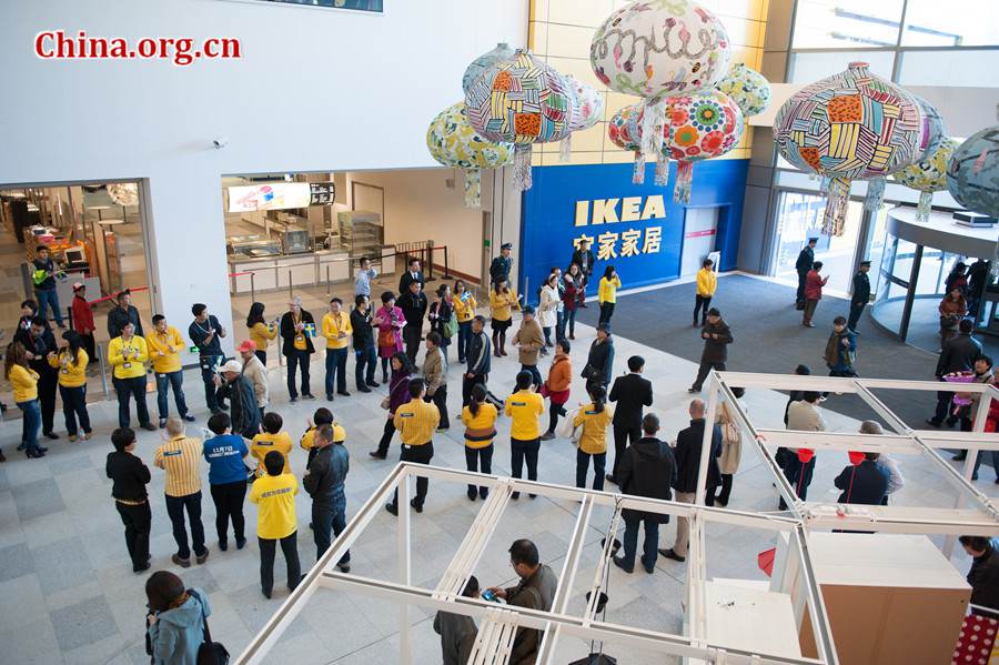 Staff members line up and clap their hands to welcome the first batch of customers at IKEA Xihongmen store, the furnishing retailer&apos;s second store in Beijing, on Thursday morning. [Photo / Chen Boyuan / China.org.cn]