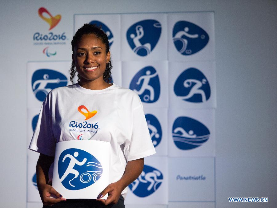 A volunteer shows a pictogram icon of triathlon that will be used for the Rio 2016 Summer Paralympic Games during their presentation by the Rio 2016 Organizing Committee in Rio de Janeiro, Brazil, on Nov. 7, 2013. (Xinhua/Xu Zijian) 