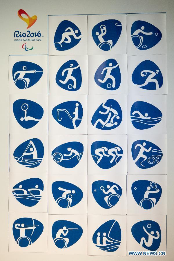 A volunteer shows a pictogram icon of triathlon that will be used for the Rio 2016 Summer Paralympic Games during their presentation by the Rio 2016 Organizing Committee in Rio de Janeiro, Brazil, on Nov. 7, 2013. (Xinhua/Xu Zijian) 