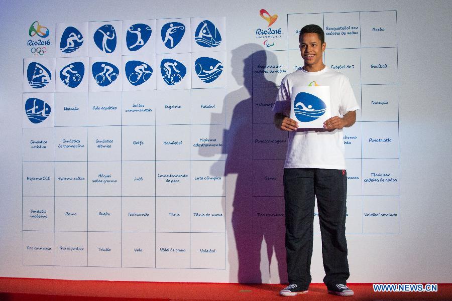 A volunteer shows a pictogram icon of swimming that will be used for the Rio 2016 Summer Olympic Games during their presentation by the Rio 2016 Organizing Committee in Rio de Janeiro, Brazil, on Nov. 7, 2013. (Xinhua/Xu Zijian) 