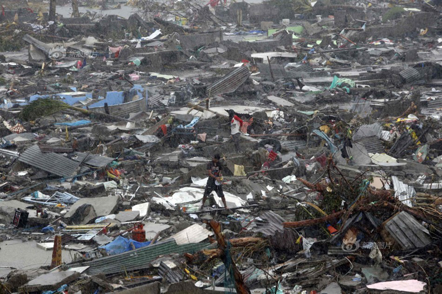 A local stands among the ruins of houses after Typhoon Haiyan rages through Tacloban City of Leyte Province, the Philippines, on Nov. 10, 2013. 